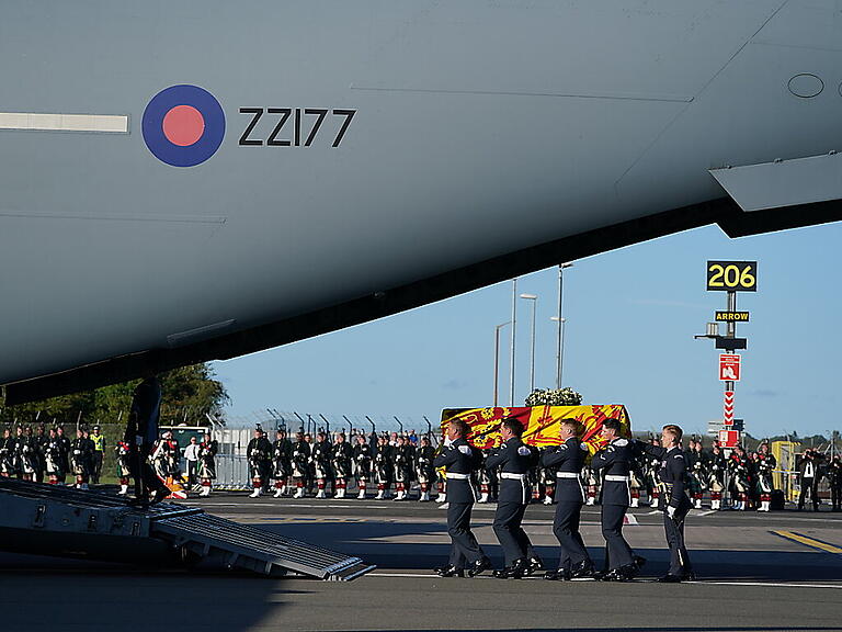 Der Sarg von Königin Elizabeth II. wird in eine Maschine der Royal Air Force getragen. Von dort aus soll er in die Hauptstadt geflogen werden. Foto: Andrew Milligan/PA Wire/dpa