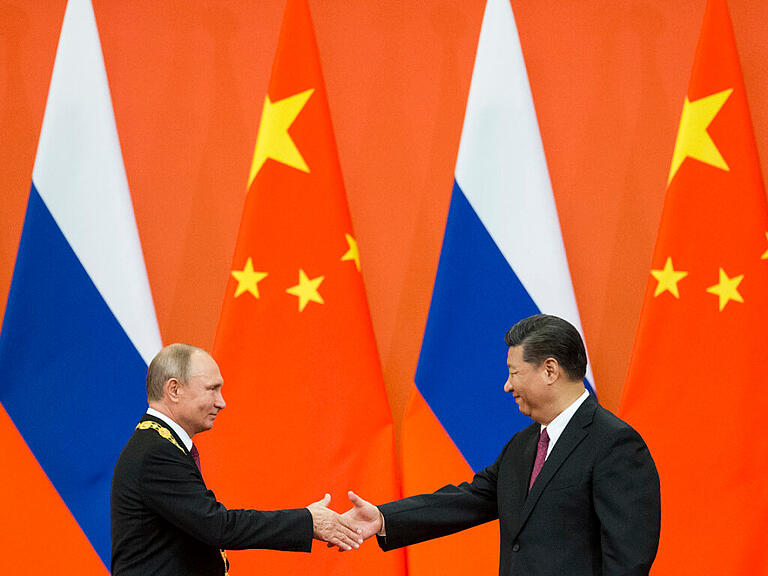 ARCHIV - Xi Jinping (r), Präsident von China, und Wladimir Putin, Präsident von Russland, schütteln sich die Hände während einer Preisverleihungszeremonie in der Großen Halle des Volkes. Foto: Alexander Zemlianichenko/Pool AP/dpa