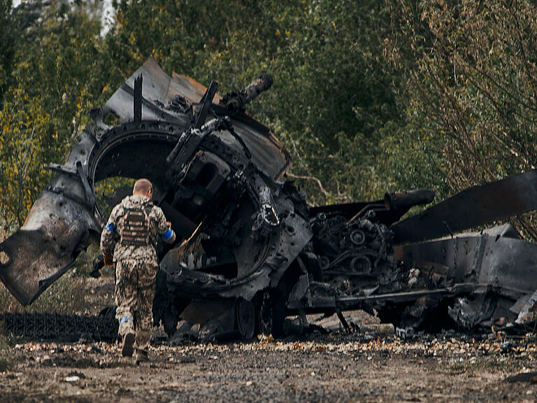 dpatopbilder - Ein ukrainischer Soldat geht an einem russischen Panzer vorbei, der bei einem Gefecht in einem gerade befreiten Gebiet auf der Straße nach Balakliia in der Region Charkiw beschädigt wurde. Foto: Uncredited/AP/dpa
