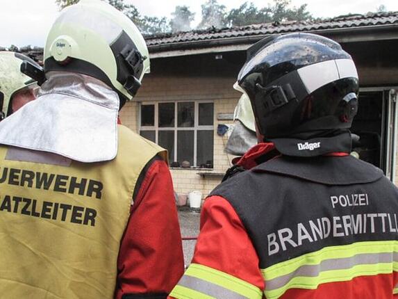Erneut Brandstiftung vermutet: Brandermittler und Feuerwehrmann am Brandort in Kriegstetten.