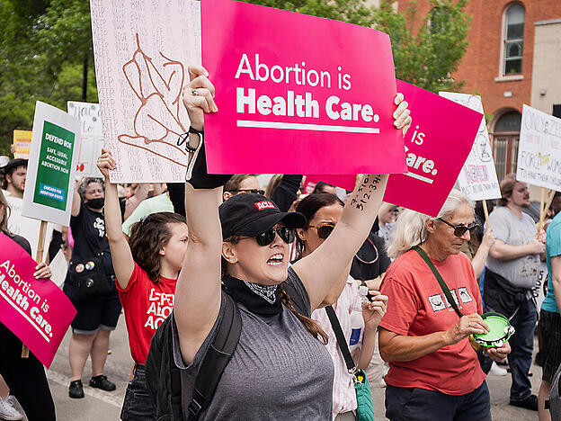 Demonstranten und Demonstrantinnen, die mit Plakaten mit der Aufschrift «Abortion is Health care» (dt. Abtreibung ist Gesundheitsvorsorge) für das Recht auf Abtreibung demonstrieren, versammeln sich im West Town. Mehre Organisation haben zu Demonstrationen im ganzen Land gegen die Verschärfung des Abtreibungsrechts in den USA aufgerufen. Foto: Pat Nabong/Chicago Sun-Times/AP/dpa - ACHTUNG: Nur zur redaktionellen Verwendung und nur mit vollständiger Nennung des vorstehenden Credits